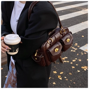 Detail of dark brown vintage underarm bag with magnetic pockets and gold hardware
