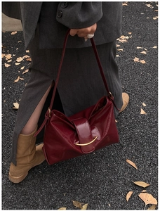 Détail du sac bandoulière en cuir bordeaux avec boucle dorée et lanière réglable