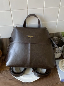 Dark brown matte PU leather backpack with gold logo and vintage flap cover design