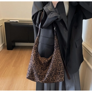 Close-up of leopard print tote bag texture and high-quality brown leather shoulder strap