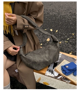 Detail showing vintage green crescent bag with contrast stitching on autumn street