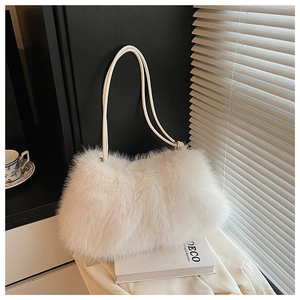 Close-up of white plush shoulder bag with long faux fur texture and leather strap