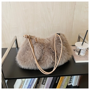 Detail of taupe plush pillow bag with gold metal ring and leather shoulder strap