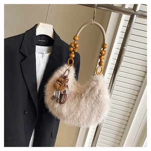 Close-up of fuzzy crescent bag with wooden bead handle and leopard print bow detail