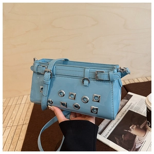 Close-up of sky blue patent leather bag featuring silver hollow rings and metal rivets