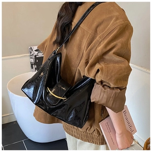 Détail du sac cabas en similicuir noir verni avec boucle métallique dorée en demi-lune