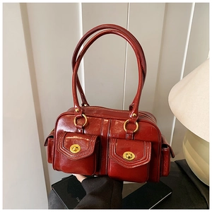 Close-up of deep red vintage Boston bag featuring glossy finish and gold clasp pockets
