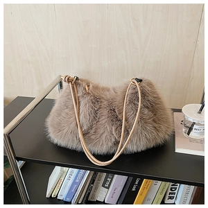 Detail of soft brown faux fur shoulder bag with slender straps and gold metal hardware