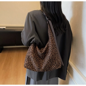 Close-up of a large leopard print tote bag worn with a gray suit for a chic office look