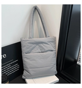 Close-up of gray quilted puffer tote bag with soft cloud texture and matching strap