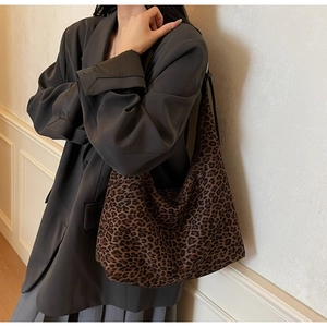Detailed side view showing the slouchy silhouette of a leopard print hobo tote bag