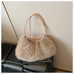 Detailed macro view of soft khaki faux fur texture and leather straps on plush tote bag