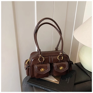 Detailed view of brown retro underarm bag with gold twist locks and dual shoulder straps
