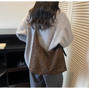 Macro view of vintage leopard print suede shoulder bag with soft hobo structure and texture