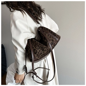 Detail view of stylish leopard print tote bag with brown leather shoulder straps