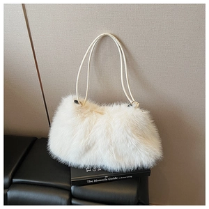 Close-up of fluffy white faux fur texture and slim shoulder strap on the fashion tote bag