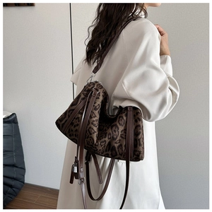 Detail of leopard print tote bag with brown leather drawstring and silver padlock charm