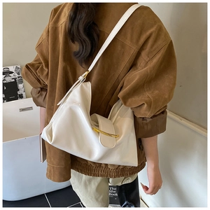 Sac hobo minimaliste en cuir verni blanc avec boucle en métal doré porté à l'épaule