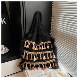 Gros plan détaillé des glands colorés et motifs de vagues dorées sur un sac en tricot