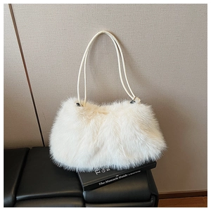 Close-up of white plush faux fur texture on a minimalist pillow-style shoulder bag
