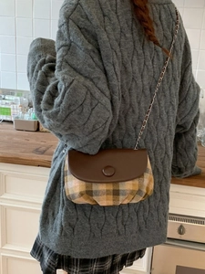 Retro plaid saddle bag with brown leather flap and silver chain strap shown on a model