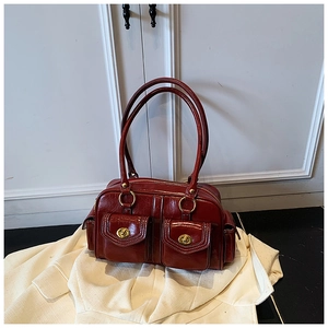 Detail of vintage dark red leather pillow bag with gold twist locks and front pockets