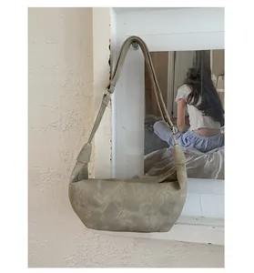 Detail of sage green hobo bag with adjustable wide strap and matte suede texture
