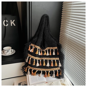 Détail d'un sac cabas en tricot bohème avec des glands colorés dans un décor intérieur