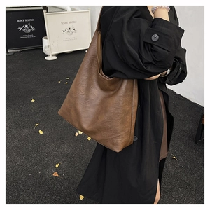 Brown large capacity hobo tote bag in leather texture shown in street style scene