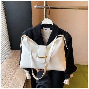 Gros plan sur un sac fourre-tout en cuir verni blanc avec boucle dorée et bandoulière