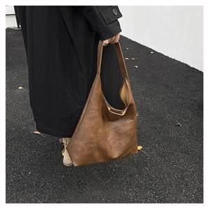 Close-up of a large dark brown Hobo bag with vintage leather texture and wide strap