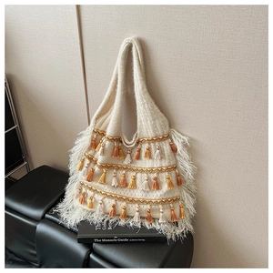 Détail du sac cabas bohème en tricot avec pompons décoratifs et franges texturées