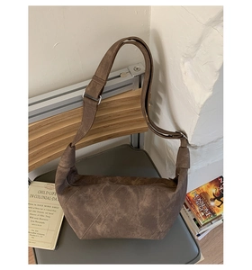 Detailed view of dark brown crescent bag with suede texture and diagonal stitching