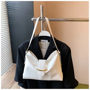 Détail du sac à main en cuir verni blanc avec fermoir en métal doré sur le rabat avant