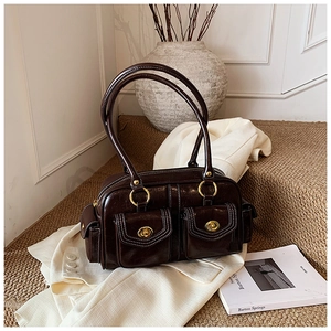 Detail view of dark brown retro Boston bag with gold twist locks and contrast stitching
