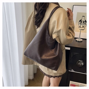 Detail view of large dark brown leather tote bag showing rich texture and hobo style