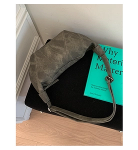 Top-down view of a grey crescent shoulder bag with matte texture and adjustable strap