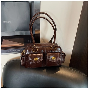 Detail of dark brown oil wax leather shoulder bag with vintage gold ring buckle hardware
