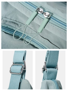 Detail view of durable dual zippers and adjustable woven strap on a mint blue tote bag