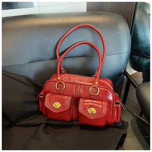 Detail view of dark red vintage Boston bag with gold twist locks and glossy leather texture