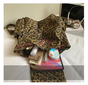 Detail view showing large capacity leopard canvas backpack with drawstring and essentials