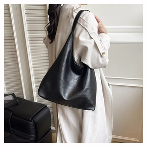 Chic black large capacity hobo bag in soft pebbled leather shown on shoulder