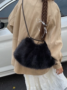 Black plush faux fur shoulder bag worn by model in a stylish autumn outdoor setting
