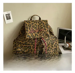 Detailed shot of leopard print canvas backpack with red embroidery and drawstring design