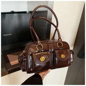 Detail of dark brown vintage Boston bag featuring double front flap pockets with gold hardware
