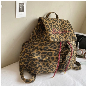 Detail of leopard print canvas backpack with drawstring closure and red logo embroidery