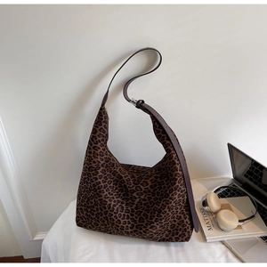 Detailed view of the leopard print texture and adjustable shoulder strap on a hobo bag