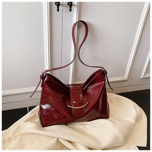 Détail du sac cabas en cuir huilé rouge-brun avec texture vintage et boucle en croissant doré