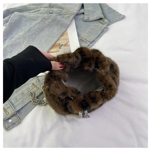 Detail of faux fur bucket bag with leopard print and silver chain strap for women