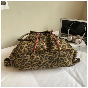 Detail of leopard print canvas backpack showing red drawstring and durable texture
